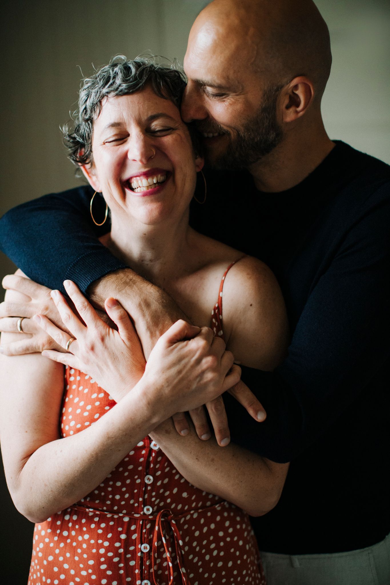 Ilya embracing Julia from behind, both laughing