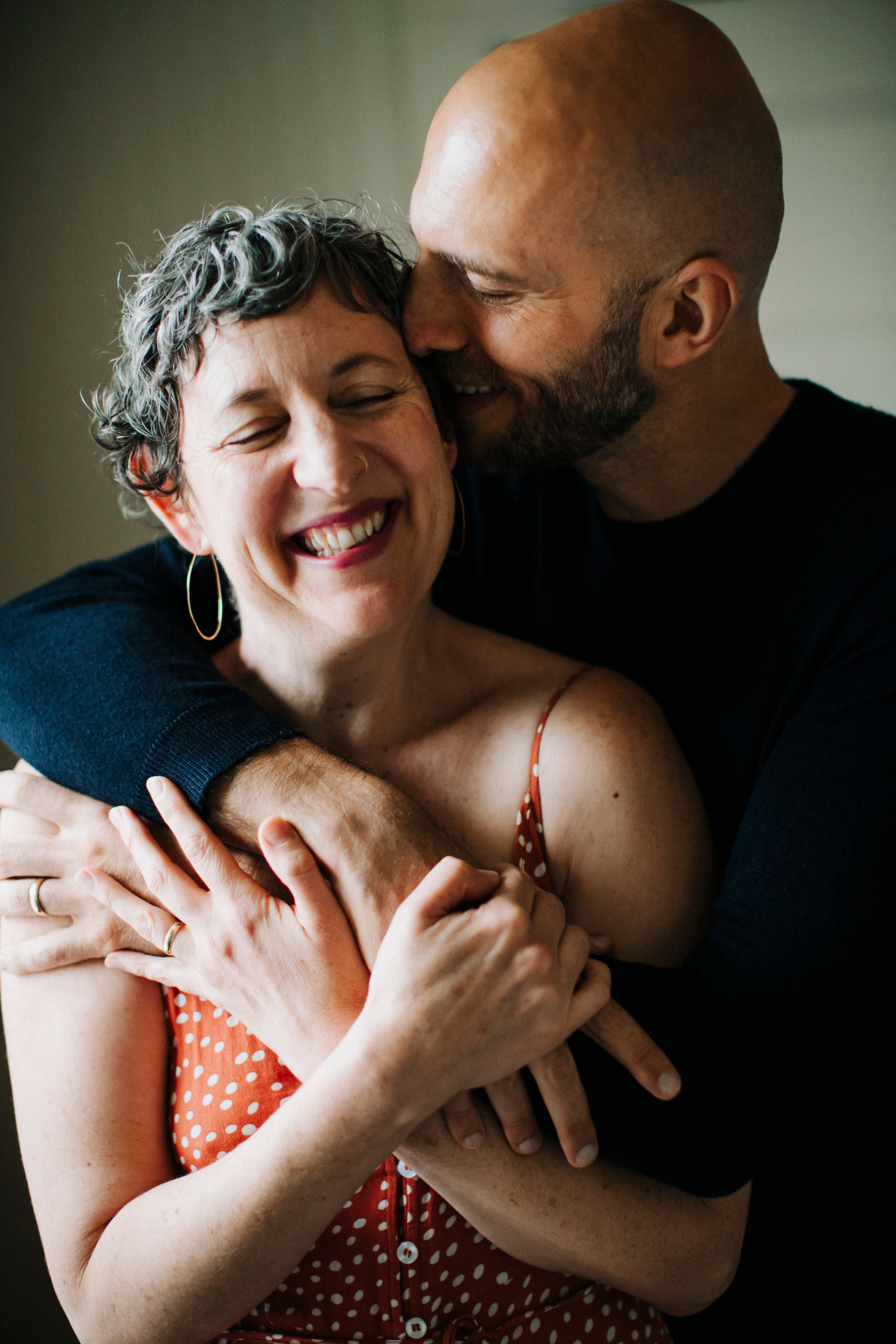 Ilya embracing Julia from behind, both laughing