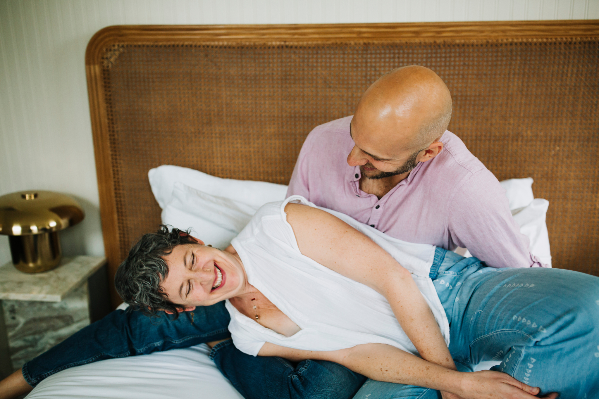 Julia and Ilya laughing together on a bed