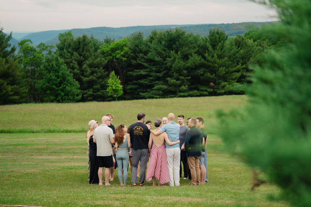 The community gathered in a circle in a mountain meadow