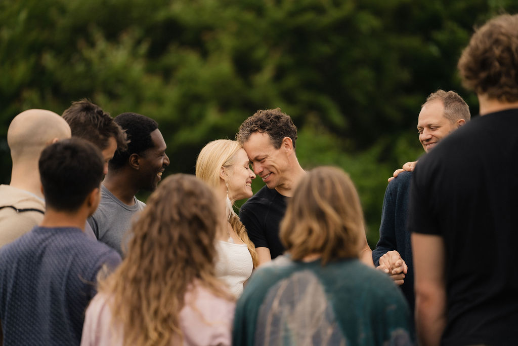 Julia and Ilya forehead to forehead, surrounded by the community